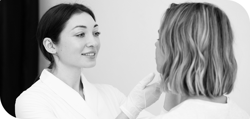 A black and white photo of a provider applying ariessence pure PDGF+ to a woman