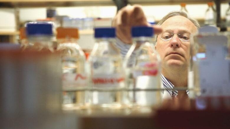 Dr. Samuel Lynch reaches for a bottle in a laboratory